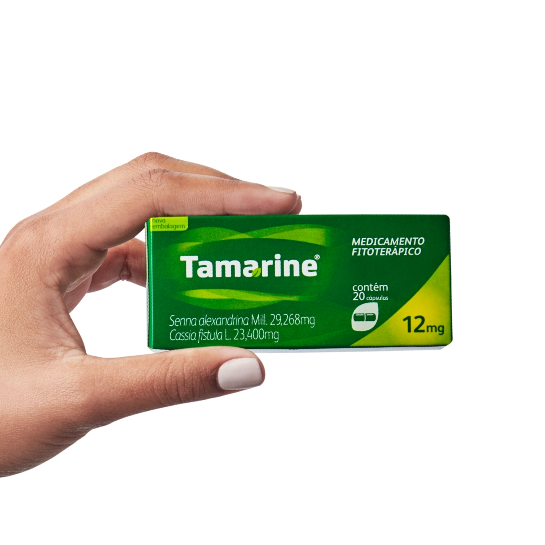 Imagem de uma mão segurando a embalagem do produto Tamarine Cápsulas 12mg