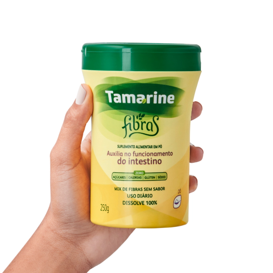 Imagem de uma mão segurando a embalagem do produto Tamarine Fibras Pó Solúvel
